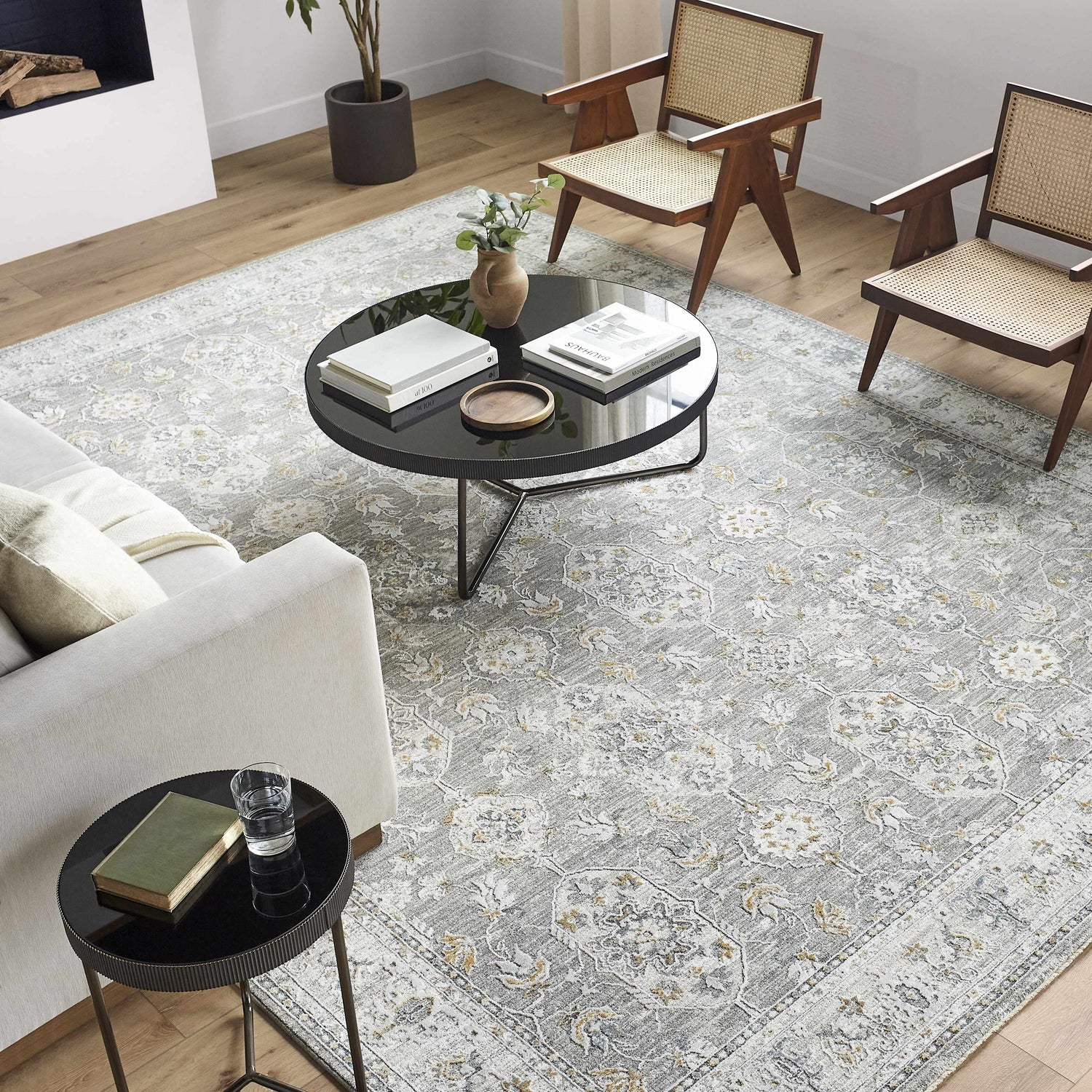 Living room scene with a gray Hafsa Textured Rug, white sofa, black tables, and mid-century modern chairs. Roomscene-Rectangle