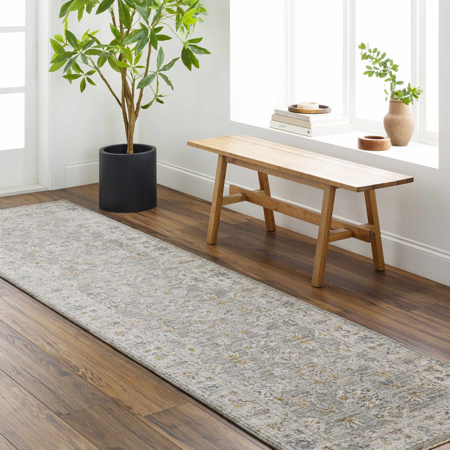Entryway with Hafsa Textured Rug runner, wood floors, bench by window, and potted plant. Roomscene-Runner