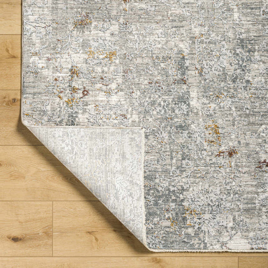 Close-up of the Ifama Textured Rug with Fringes. Abstract design in gray, light brown, and off-white. Fold
