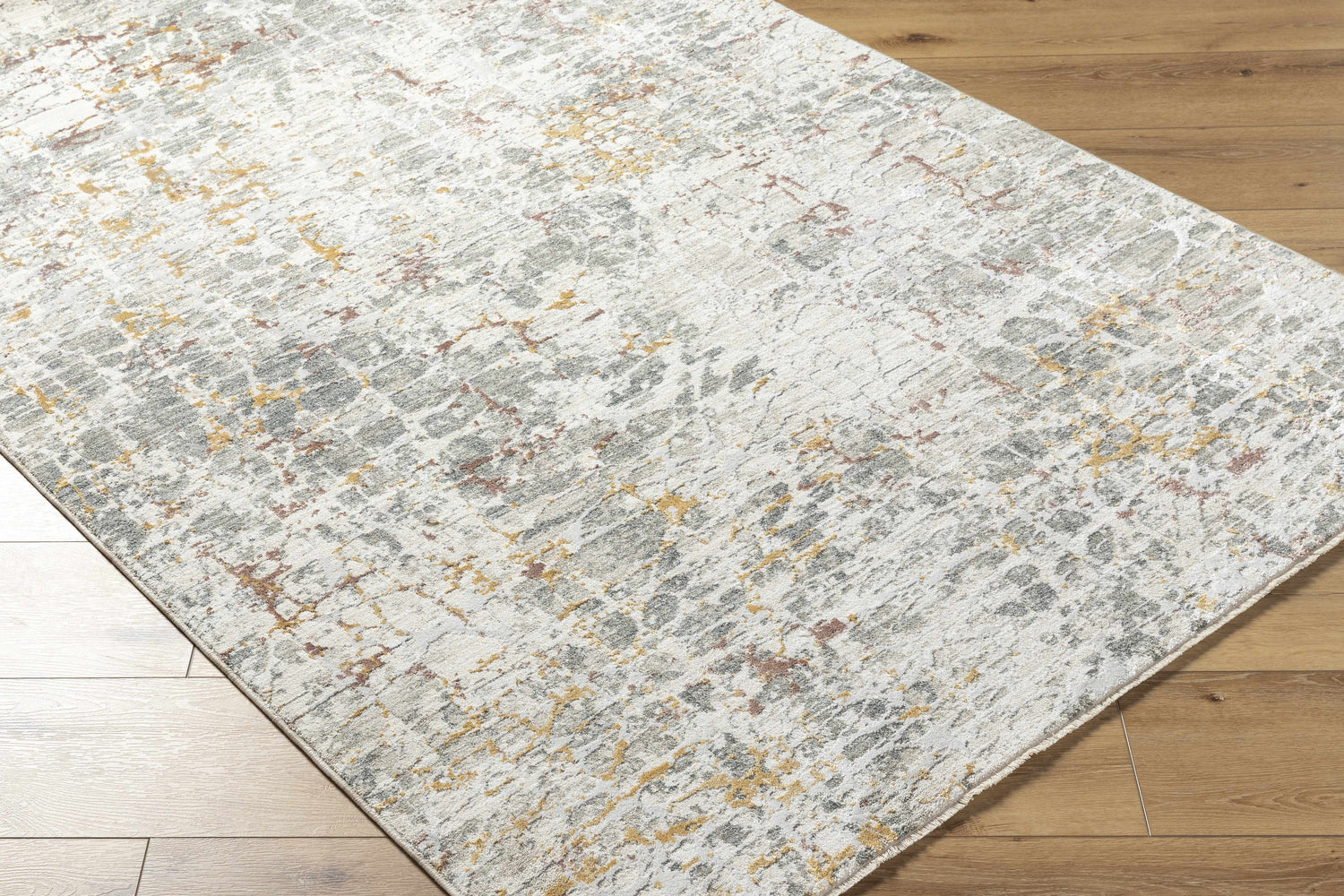 Close-up of Kasim Textured Rug with Fringes. Light gray, white, gold, and brown abstract pattern. Contemporary style. Corner