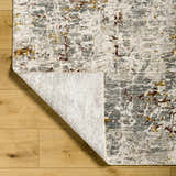 Close-up of the Kasim Textured Rug in light gray, showing its abstract pattern and texture on a wood floor. Fold