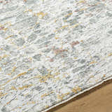 Close-up of the Kasim Textured Rug. Light gray rug with gold and blush accents. Contemporary style. Texture
