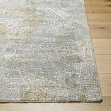 Close-up of the Mila Textured Rug. Features a contemporary abstract design in cloud gray, light gray, and beige on wood floors. Front