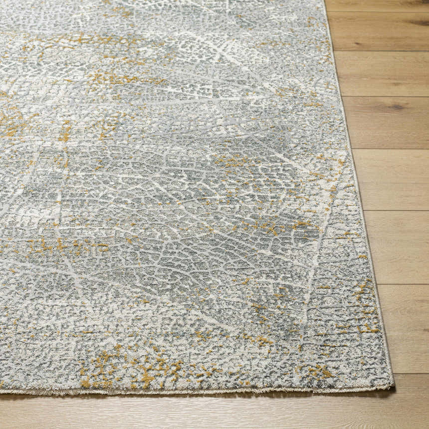 Close-up of the Mila Textured Rug. Features a contemporary abstract design in cloud gray, light gray, and beige on wood floors. Front