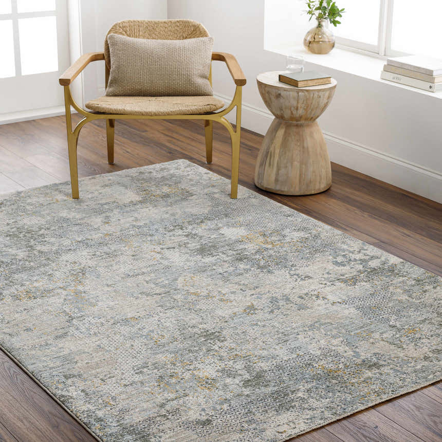 Living room scene with a Pizi Textured Rug in dusty sage, light gray, and mustard under a chair. Roomscene-Rectangle
