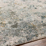 Close-up of the Pizi Textured Rug, showcasing its abstract design in dusty sage, ink blue, and mustard on a wood floor. Texture
