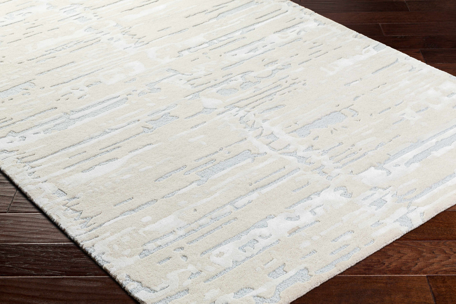 Close-up of the Kadin Cream Abstract Area Rug showing its light gray and natural gray contemporary design and hand-tufted texture. Corner