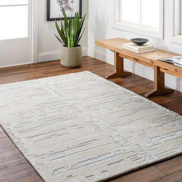 Entryway with Kadin Cream Abstract Area Rug, wood bench, potted snake plant, and dark wood floors. Roomscene-Rectangle