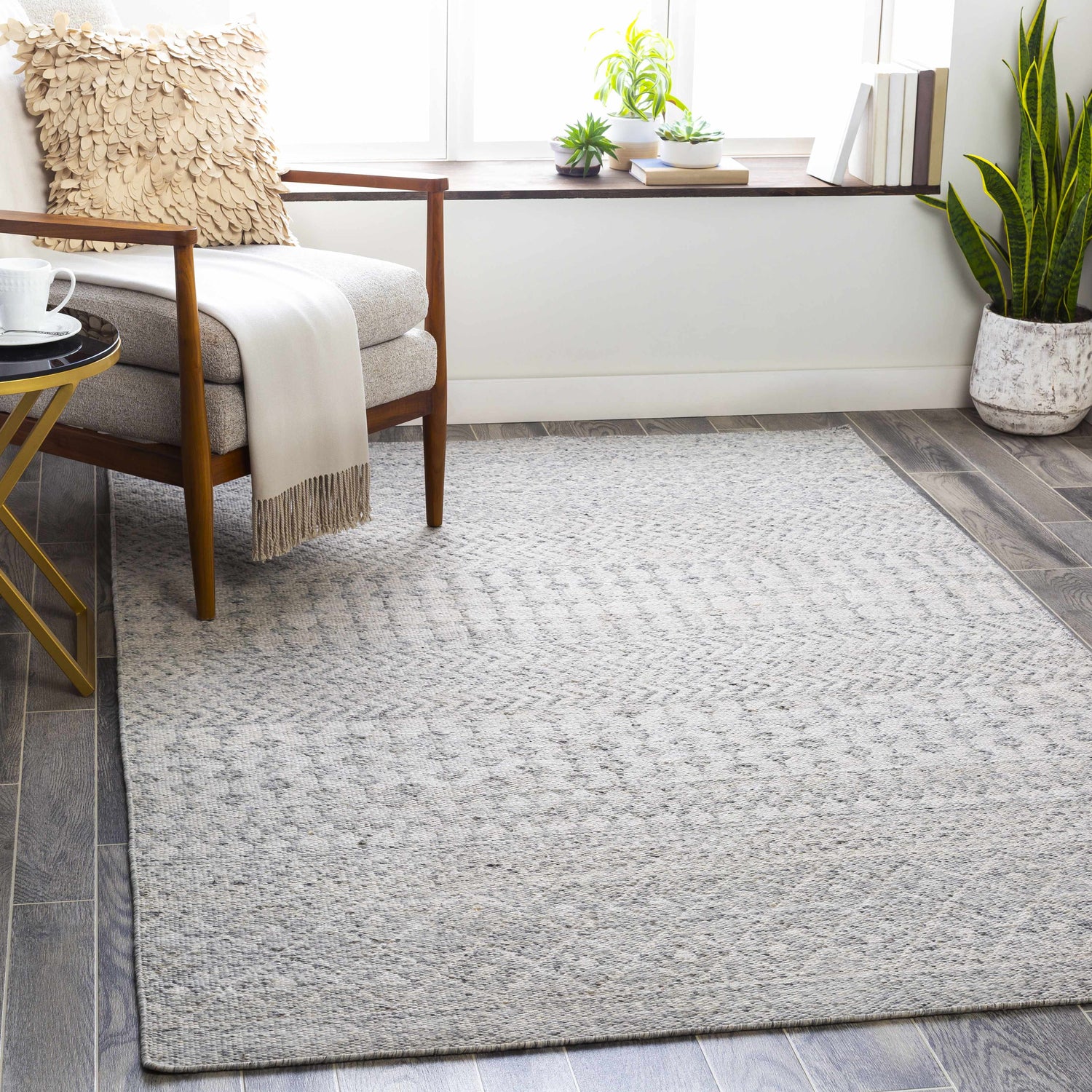 Living room scene with gray Seafield Indoor Outdoor Rug, chair, side table, and plants. Bohemian, transitional style. Roomscene-Rectangle