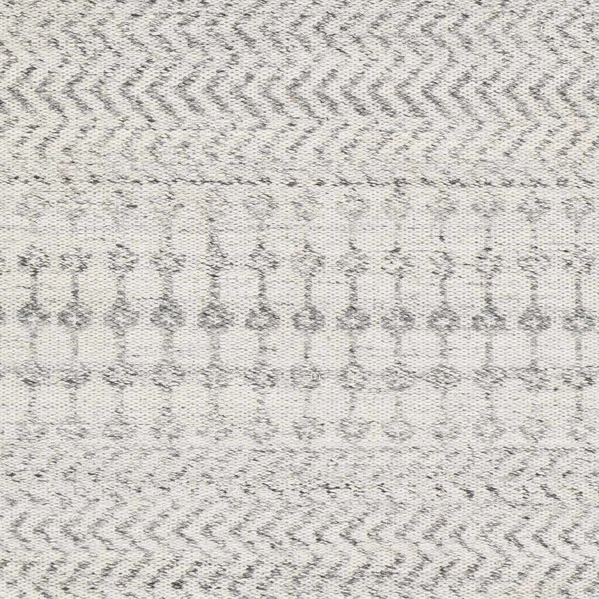 Close-up of the Seafield Indoor Outdoor Rug in gray, off-white, and slate blue with a woven bohemian pattern. Swatch