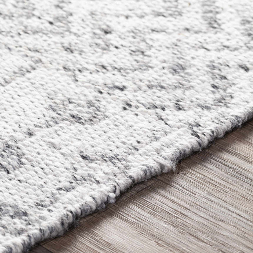 Close-up of the hand woven Seafield Indoor Outdoor Rug. Gray, off white, and slate blue recycled PET yarn. Texture