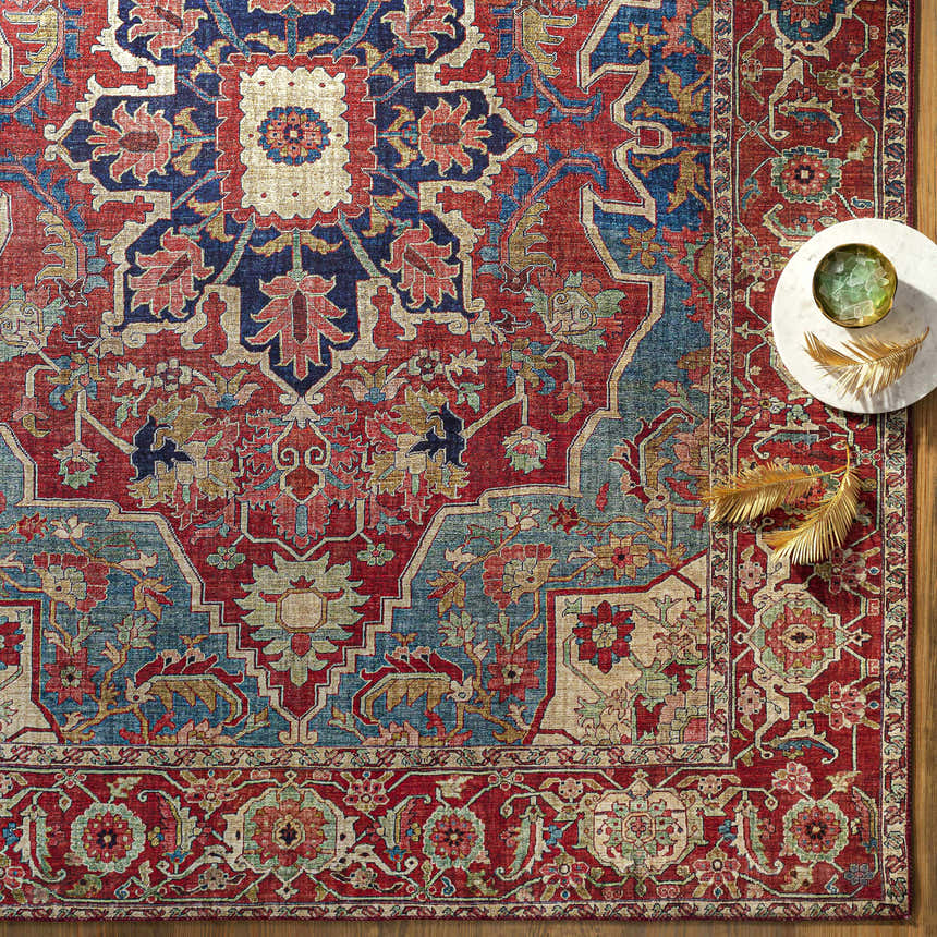 Close-up of the Seattle Area Rug in beige, burnt orange, and blue with a traditional floral pattern. Styleshot