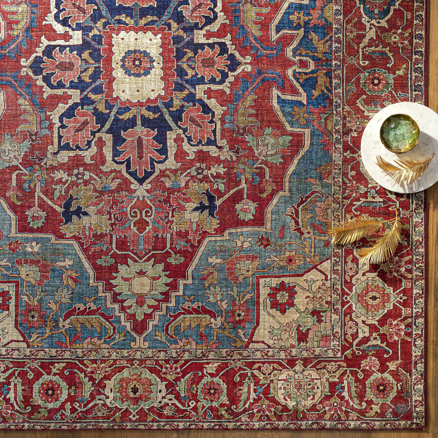 Close-up of the Seattle Area Rug in beige, burnt orange, and blue with a traditional floral pattern. Styleshot