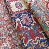 Close-up of the Seattle Area Rug - Clearance, showing its traditional red, blue, and beige Oriental-style pattern. Fold