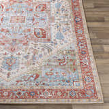 Close-up of the Selbyville area rug showing its brick red, light blue, and ivory Oriental-inspired pattern. Front