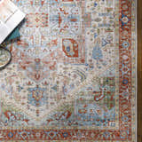 Close-up of the Selbyville area rug showing its brick red, blue, and ivory bohemian-inspired design and machine-woven texture. Styleshot