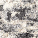 Close-up of the Selcuklu Area Rug, a shag rug in black, cream, light beige, and light gray. Abstract pattern. Swatch
