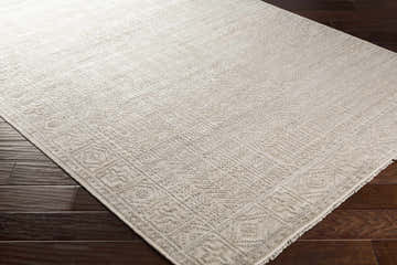 Close-up of the beige Selfridge Area Rug showing the hand-knotted wool texture and traditional geometric pattern. Corner