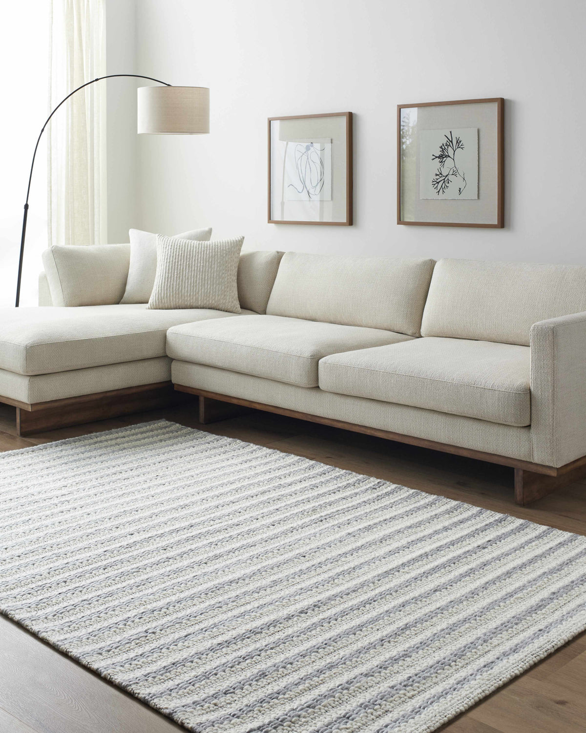 Living room scene with a beige sectional sofa and a striped Laleh Gray Area Rug. Roomscene-Rectangle