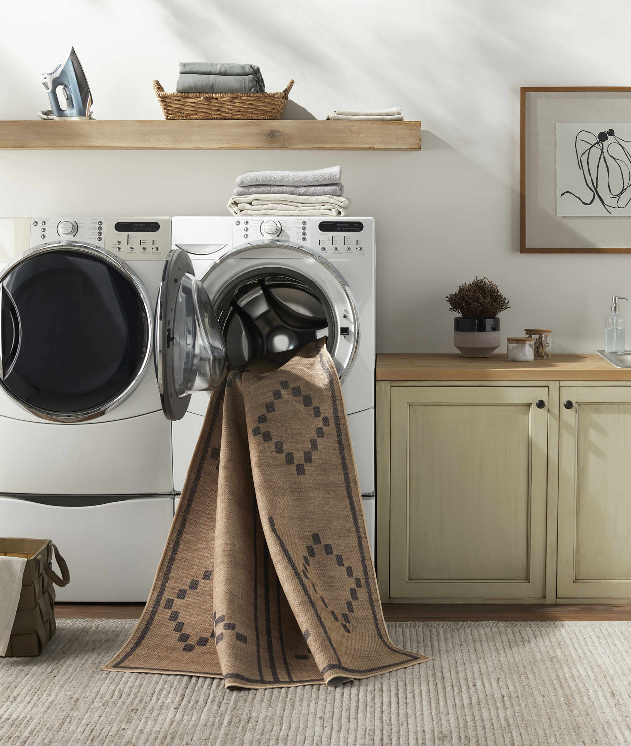 Laundry room with Fathi Washable Area Rug in camel and brown partially inside the washing machine. Farmhouse style decor. Washing-Machine