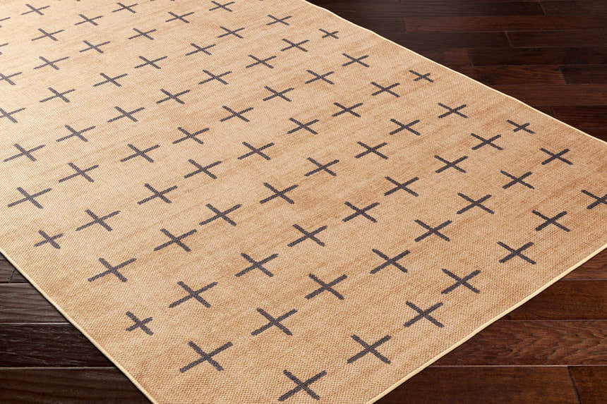 Close-up of Haimi Black Washable Jutely Rug showing camel color and dark gray plus sign pattern on dark wood floor. Corner
