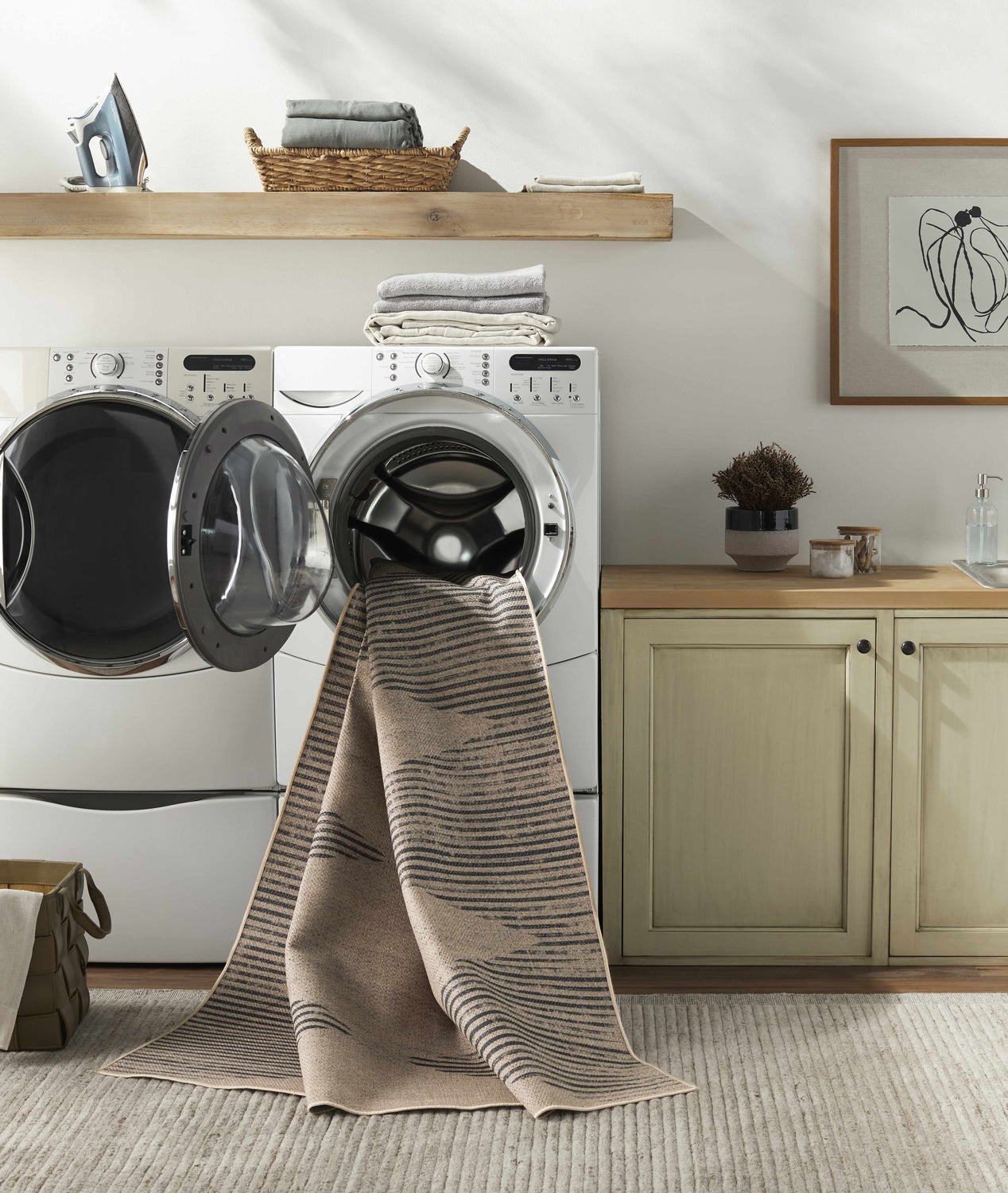 Laundry room with Ijlal Washable Area Rug draped from the washing machine, showing its camel and dark brown stripes. Washing-Machine