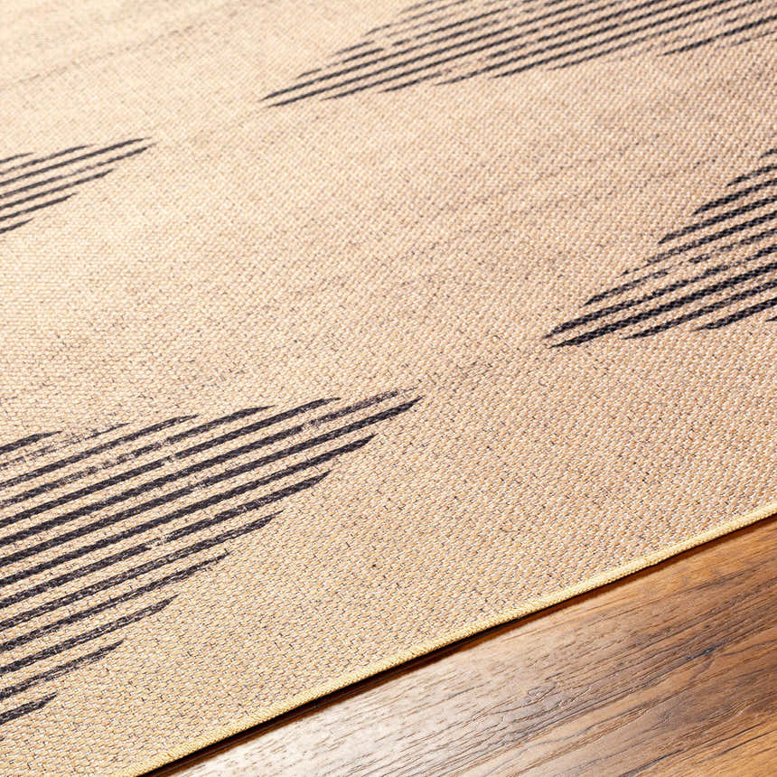 Close-up of the Ijlal Washable Area Rug showing a camel background with a dark brown geometric striped pattern. Texture