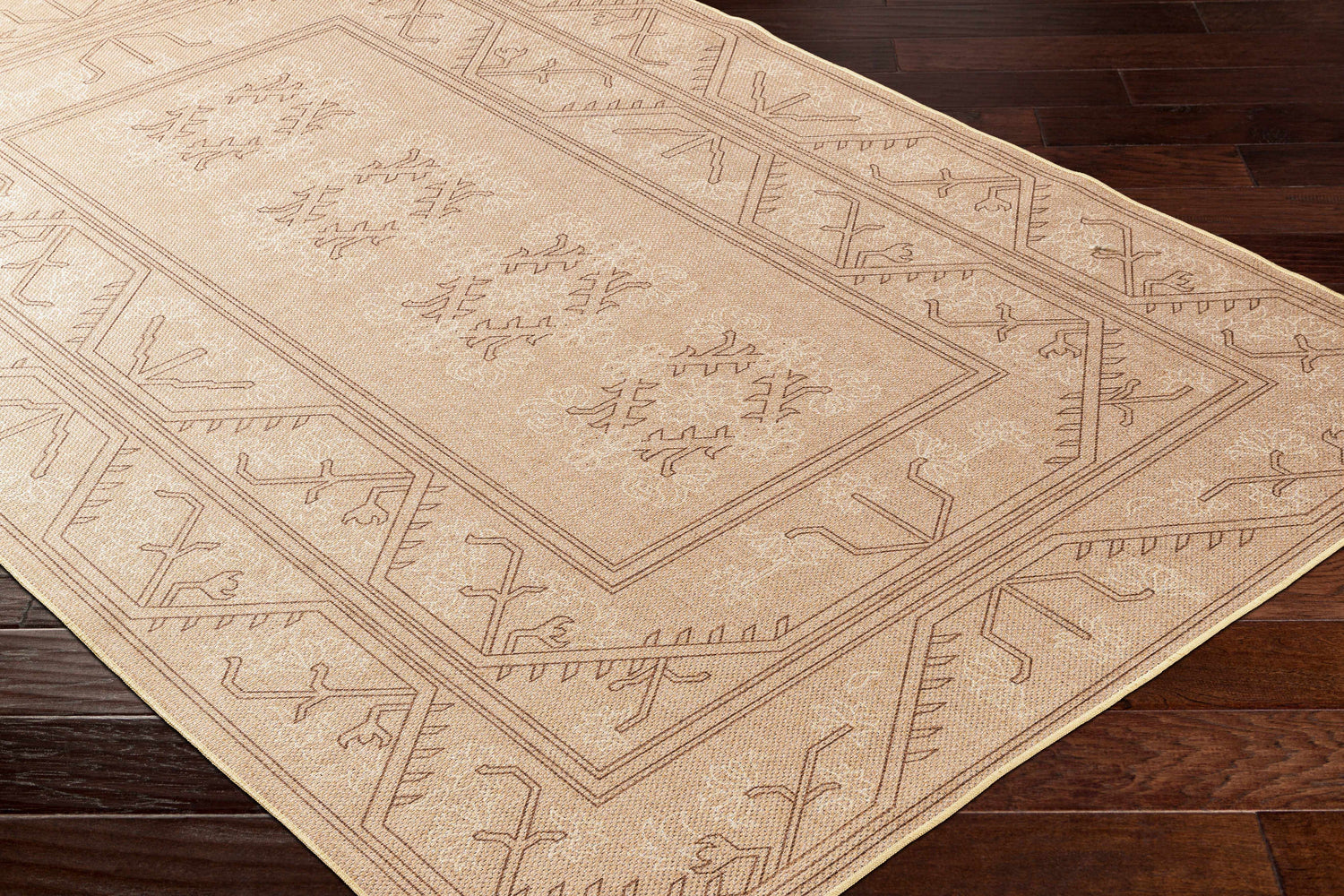 Close-up of the Naja Washable Area Rug in tan. Features a geometric, farmhouse-style pattern and a machine-woven construction. Corner