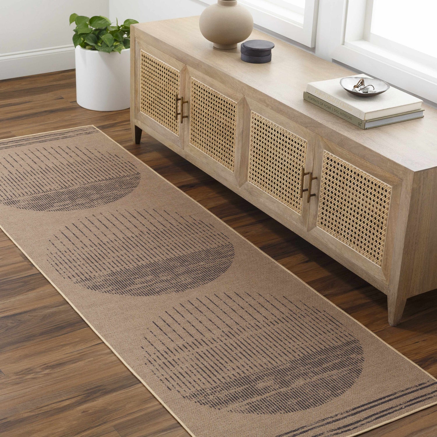 Entryway with a camel Yuki Washable Area Rug runner featuring a geometric circle design, paired with a light wood console table. Roomscene-Runner