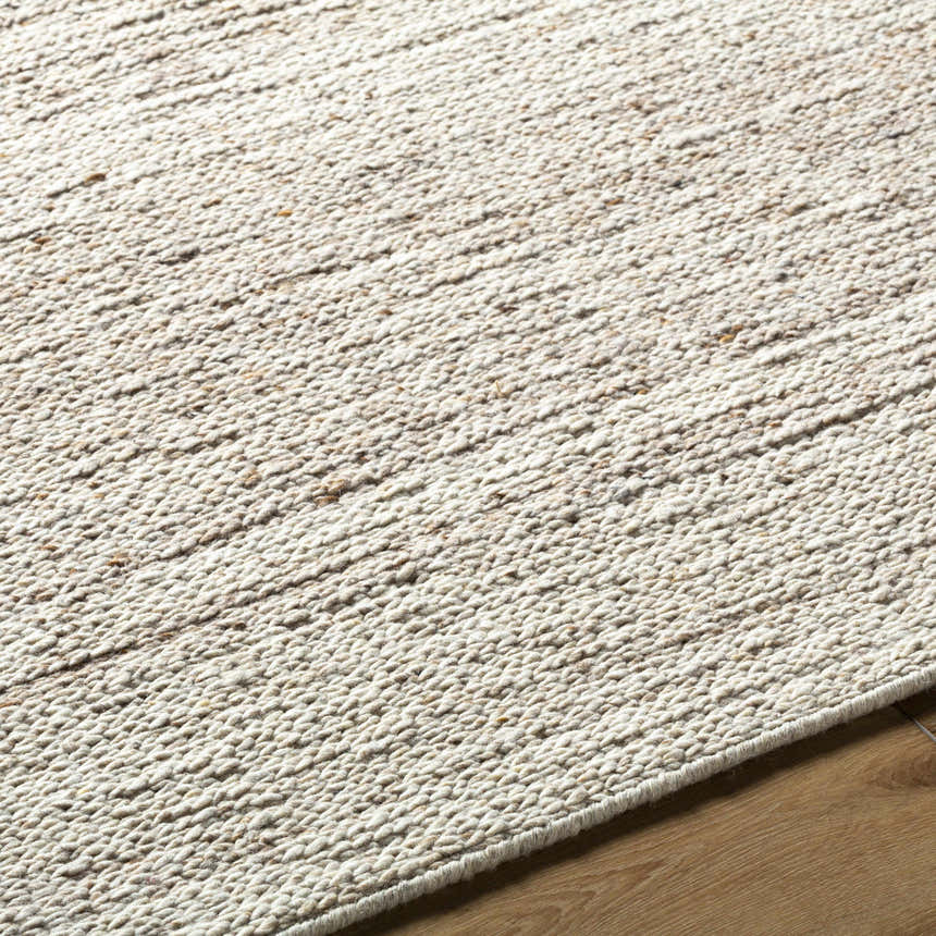 Close up of the hand tufted Urmat Wool Area Rug showing light silver, pearl, and warm gray tones. Texture