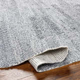 Close-up of the hand woven Chepe Area Rug, charcoal, light gray and silverton recycled yarn, contemporary style. Fold