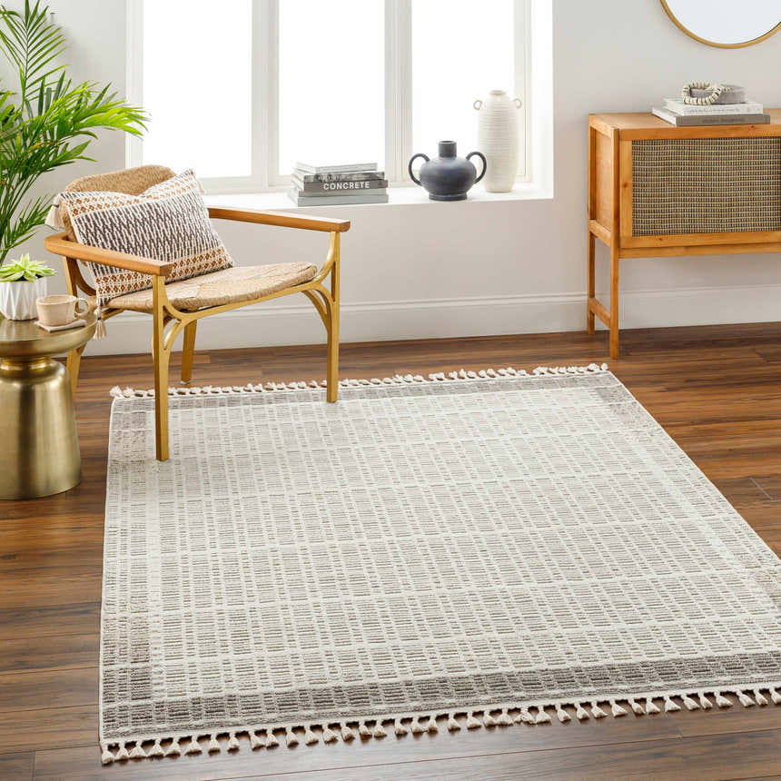 Living room scene with a beige Ajda Area Rug, woven chair, and wood cabinet. Roomscene-Rectangle