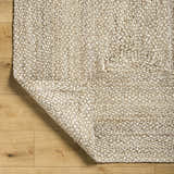 Close up of the Elkie Area Rug showing lambswool and light brown jute texture on wood floor. Fold