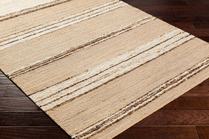 Close-up of the Arnie Area Rug showing beige, ivory, and brown stripes on dark wood floors. Hand woven texture. Corner