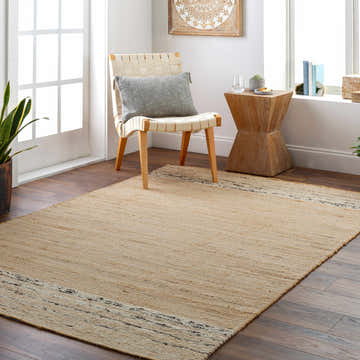 Light and airy living room with a tan Hedd Area Rug, woven chair, and wood accents. Roomscene-Rectangle