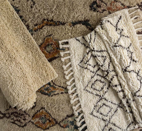 Close-up of Lothian Area Rug showing ivory shag texture, charcoal geometric pattern, and hand woven wool construction. Styleshot
