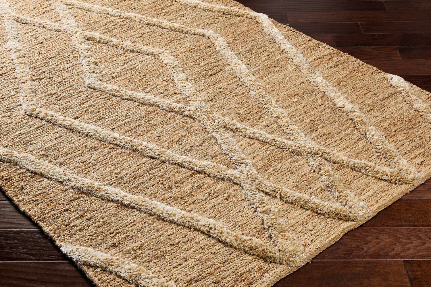 Close-up of Allie Textured Jute Rug showing natural fiber texture and raised geometric pattern on dark wood floor. Corner