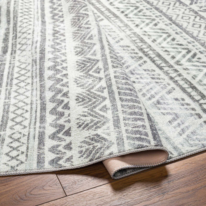 Close-up of the Ianna Light Gray Washable Area Rug showing its farmhouse-style geometric pattern and soft polyester texture. Fold