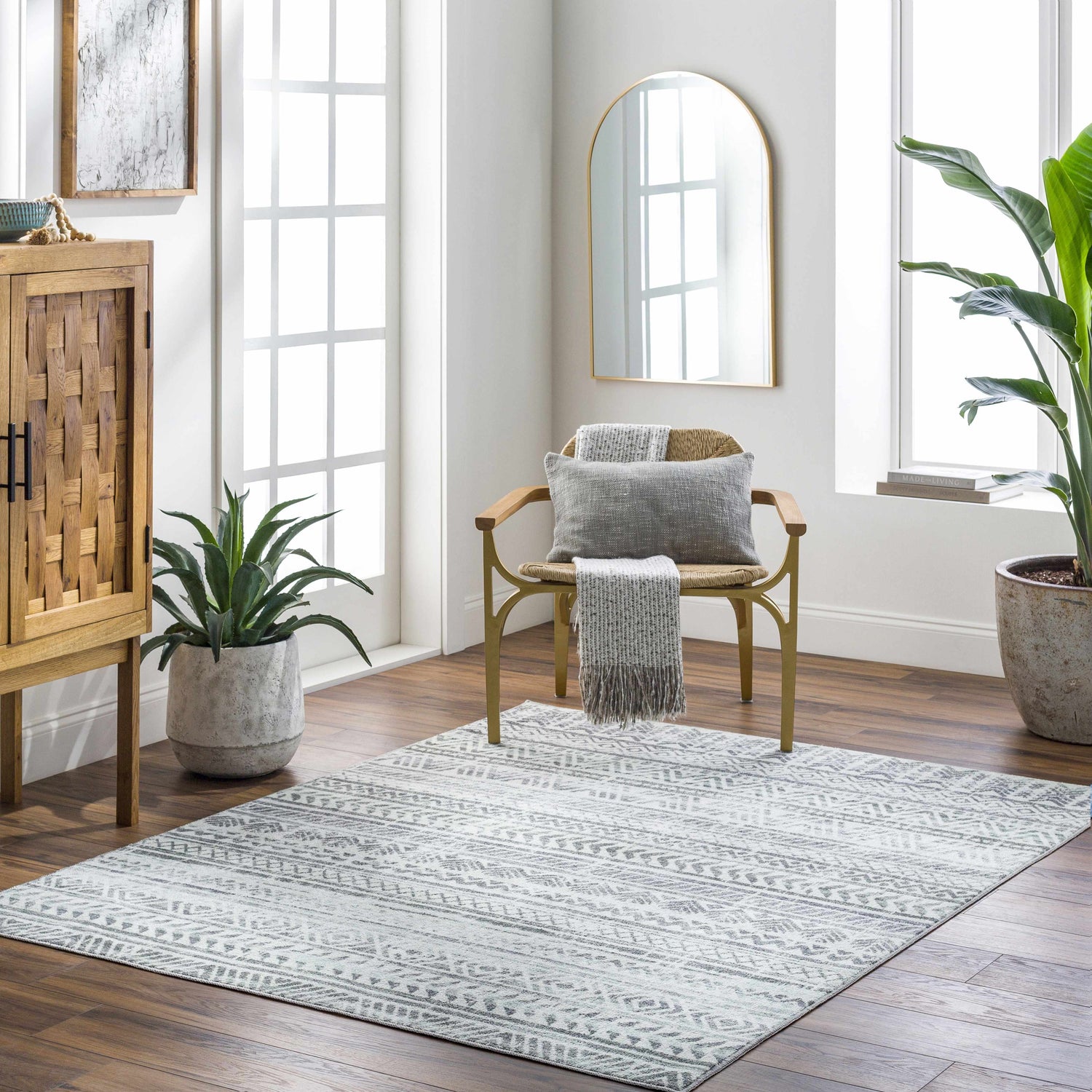 Bright living room with wood floors and Ianna Light Gray Washable Area Rug. Farmhouse style chair and cabinet. Roomscene-Rectangle