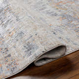 Close up of the Guoda Area Rug showing driftwood, gray, and nutmeg colors. Contemporary style, machine woven. Fold