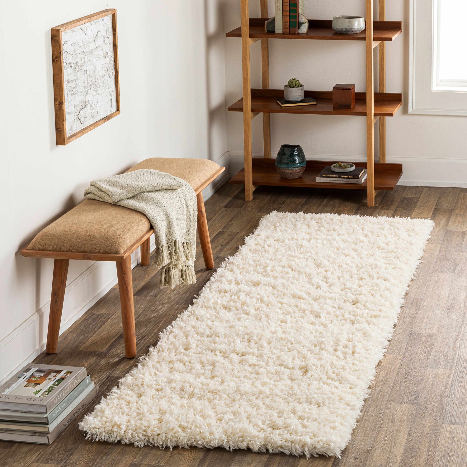 Living room scene with a cream Siari Solid Plush Rug, wooden bench, and bookshelf. Roomscene-Runner
