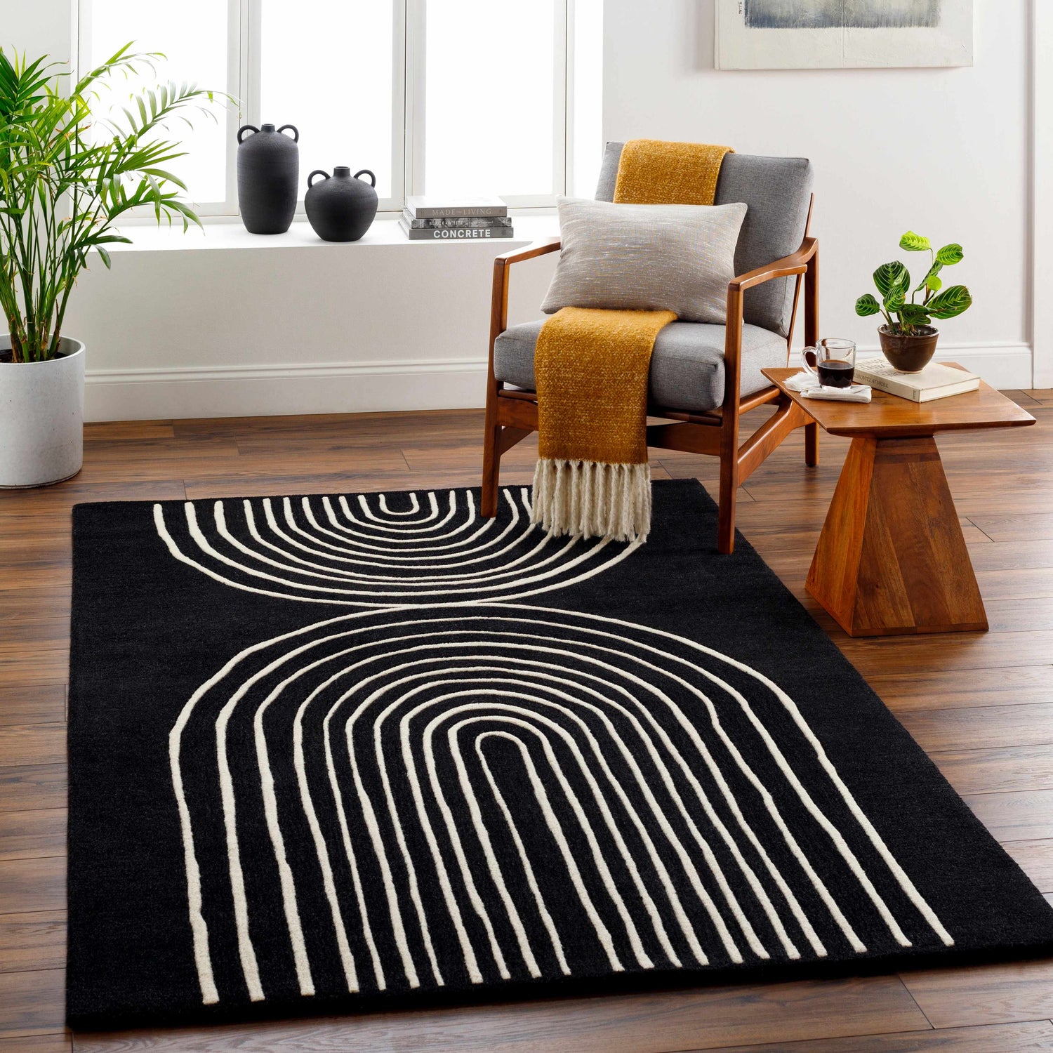 Living room scene with a black Fuat Wool Rug. The rug features a modern white arc design. Roomscene-Rectangle