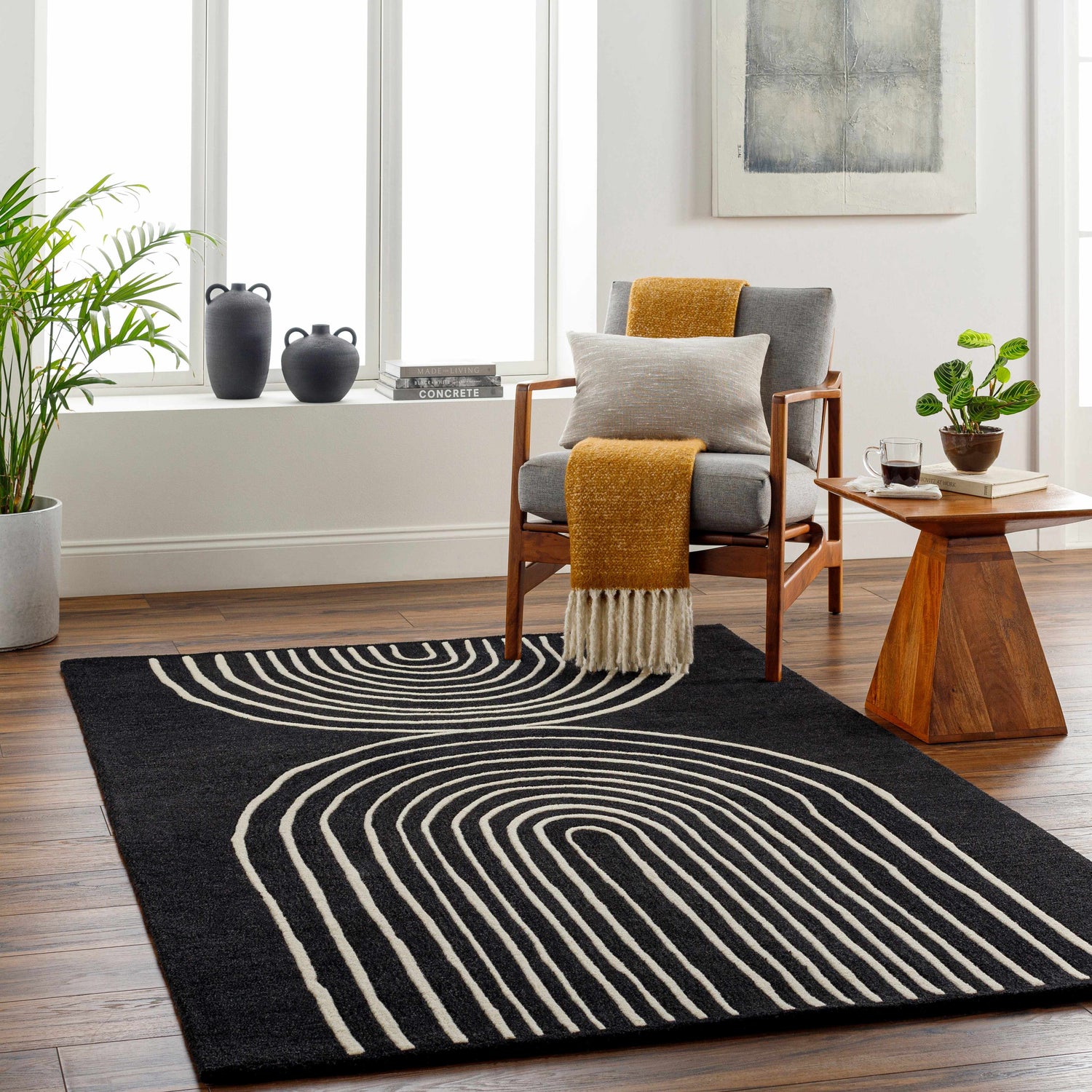 Living room scene with a Fuat Black Wool Rug, gray chair, wood side table, and modern decor. Roomscene-Rectangle