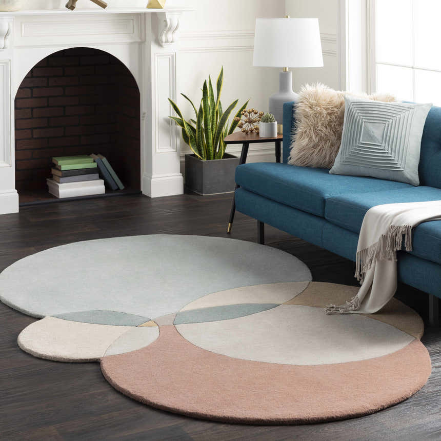 Living room with a blue sofa and round Simla Novelty Wool Rug with gray, beige, and peach circles. Roomscene-Custom