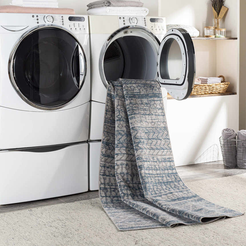 Laundry room scene with Tambac Blue Washable Area Rug coming out of the dryer. Farmhouse style, blue and gray rug. Washing-Machine