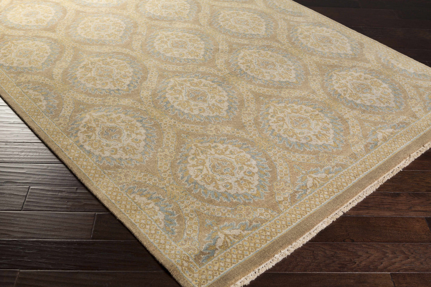 Close up of the hand-knotted Olson Area Rug. Contemporary style, wool rug with beige, yellow, and blue floral pattern. Corner