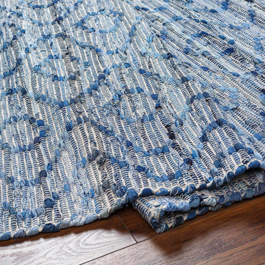 Close-up of the hand woven Gurit Blue & Brown Area Rug, a contemporary rug made of recycled fabric. Fold
