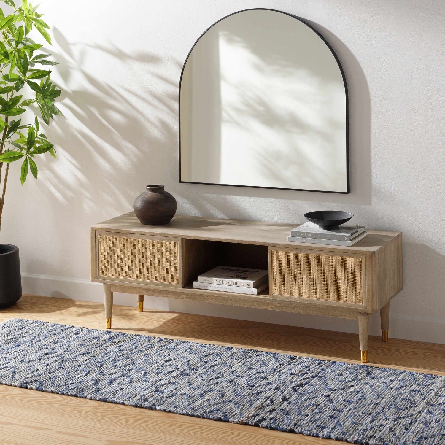 Entryway scene with a Gurit Blue & Brown Area Rug. The rug is styled with a wooden console table and a modern mirror. Roomscene-Runner