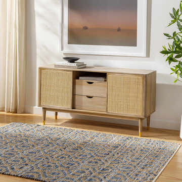 Living room scene with a blue and beige Isaye Blue Area Rug, light wood console table, and neutral decor. Roomscene-Rectangle