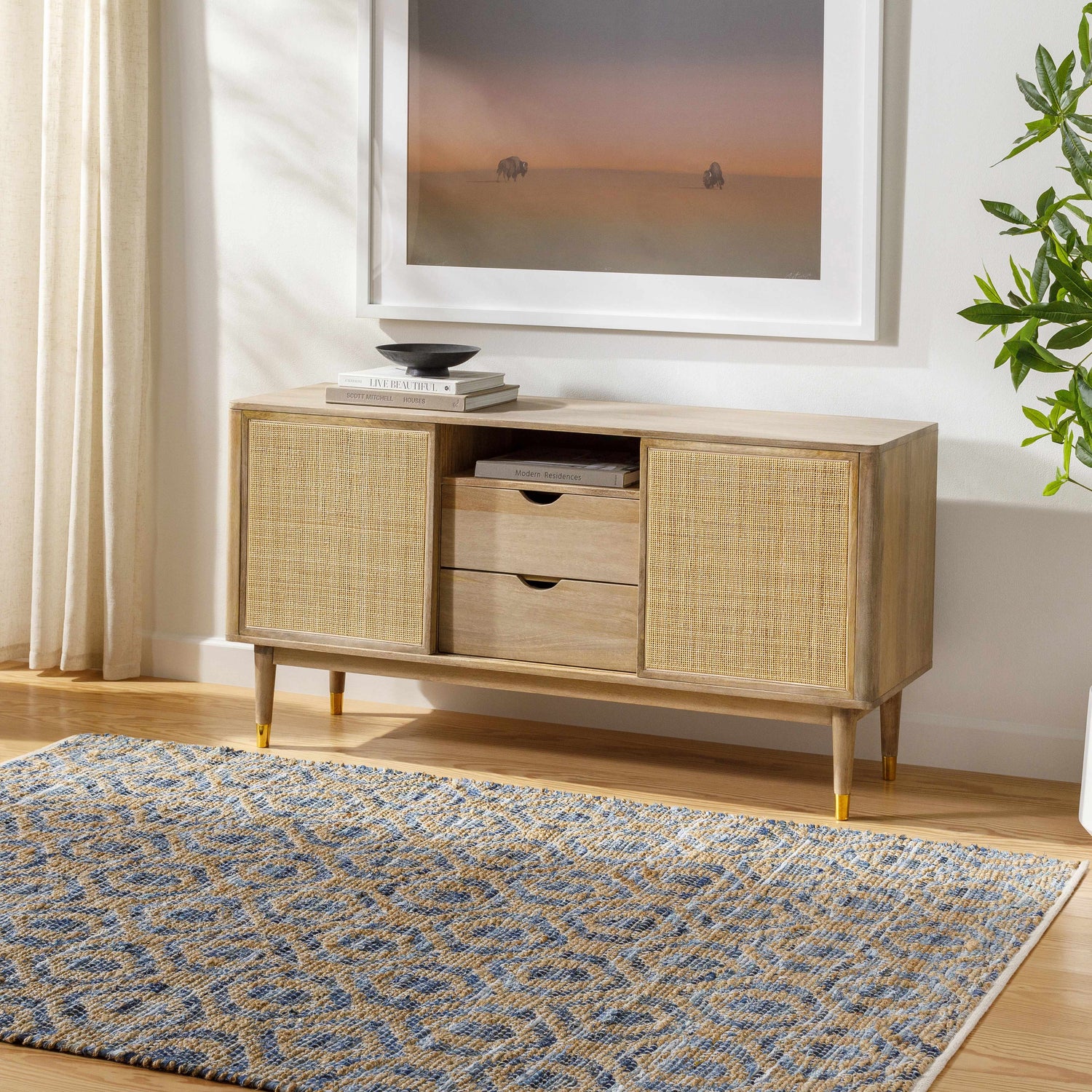 Living room scene with a blue and beige Isaye Blue Area Rug, light wood console table, and neutral decor. Roomscene-Rectangle